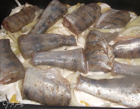 Картофель почистить, нарезать ломтиками. Лук — полукольцами. В форму налить растительное масло. Уложить слой картофеля, посолить. Смазать сметаной, уложить сверху лук и куски рыбы.