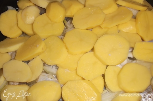 На рыбу выложить снова лук и картошку. Посолить. Накрыть форму фольгой и поставить в духовку на 50 минут при 220°C. Посыпать сыром и убрать в духовку еще на 10 минут.