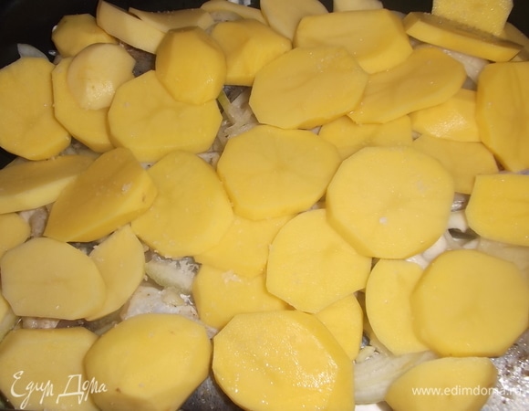 На рыбу выложить снова лук и картошку. Посолить. Накрыть форму фольгой и поставить в духовку на 50 минут при 220°C. Посыпать сыром и убрать в духовку еще на 10 минут.