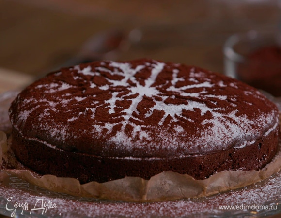 Используя любой трафарет, например в виде снежинки, посыпать теплый пирог оставшейся сахарной пудрой и какао.