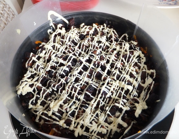 Следующий слой — чернослив с майонезной сеточкой.