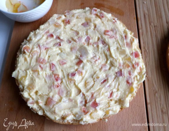 Промазать один из коржей кремом с тропическими фруктами. Это должна быть та часть, которая являлась верхней частью выпеченного бисквита. Нижняя часть бисквита (более ровная) должна стать верхом нашего торта.