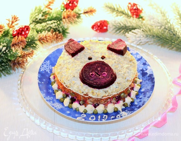 Седьмой слой — яичный желток. Украшаем салат сверху «пятачком», «ушками» из свеклы и «глазками», вырезанными из маслин. Новогодний салат готов!