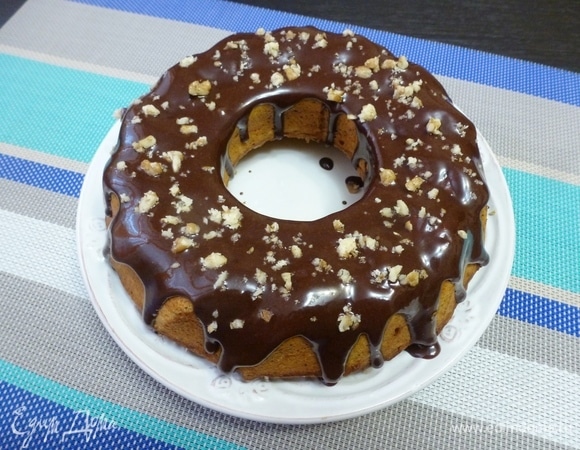 Дать кексу остыть. Пока сварить глазурь. Соединить какао и сахар, добавить сметану. Поставить на огонь и, помешивая, довести до кипения, но не кипятить. Снять с плиты и сразу добавить мягкое сливочное масло. Полить кекс глазурью и посыпать орешками. Свежий кекс при нарезке может крошиться, а через несколько часов или на следующий день режется очень хорошо.