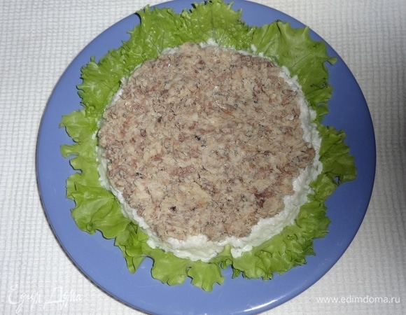 К сожалению, у меня кольца подходящего размера нет, пришлось выкладывать слои без него. На листья выложить слой риса с майонезом, далее выложить слой рыбы.