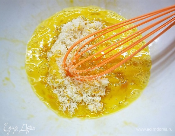 В глубокую чашку разбиваем яйца, добавляем сахар с апельсиновой цедрой и перемешиваем.