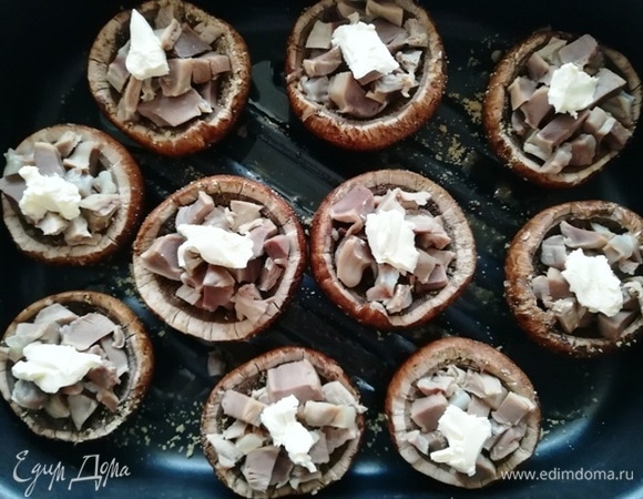 В каждую шляпку выкладываем утиные желудочки, сверху кладем небольшой кусочек сливочного масла для сочности.