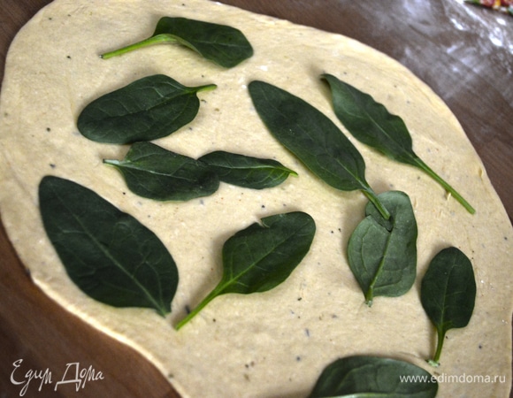 Раскатать обе части теста, на одну уложить базилик.