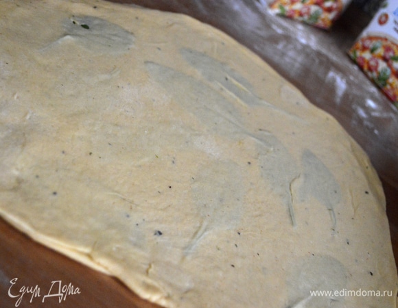 Накрыть второй частью теста и раскатать скалкой, тем самым склеив их.