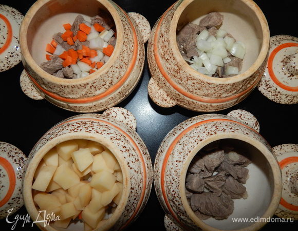 Достать мясо из кастрюли и распределить по 4-м горшочкам. Дальше — слой лука, морковки и картофеля.