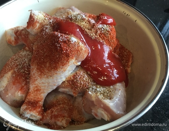 Положите в миску крылышки и голени, добавьте специи и кетчуп, посолите.