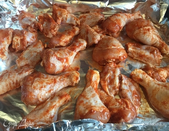 Выложить курицу на противень и готовить в предварительно нагретой духовке на режиме «Гриль» при температуре 180°C.