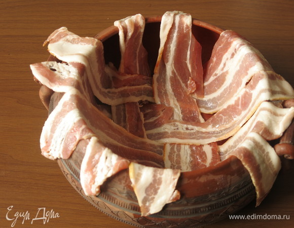 Дно горшочка смазываем маслом, выкладываем бекон.