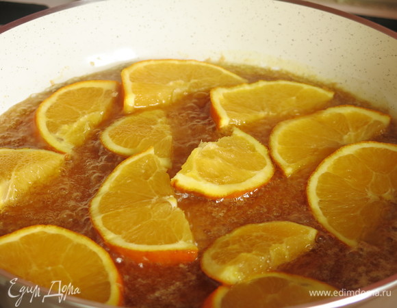 Кладем нарезанные половинками дольки апельсинов. Обжариваем сперва дольки одного апельсина, потом — другого.