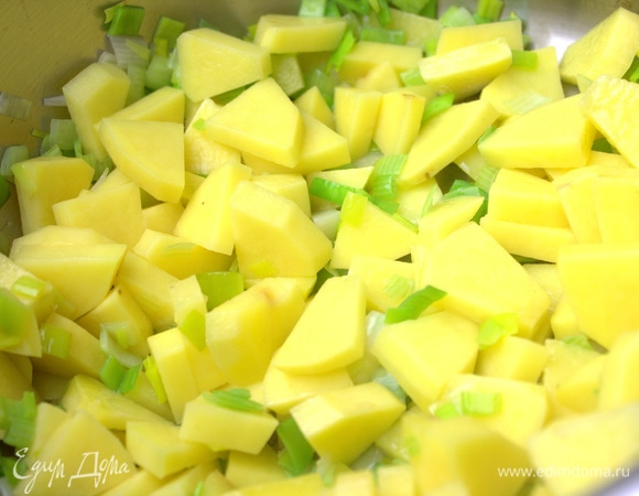 Высыпать картофель к луку и обжаривать на огне дальше, помешивая.