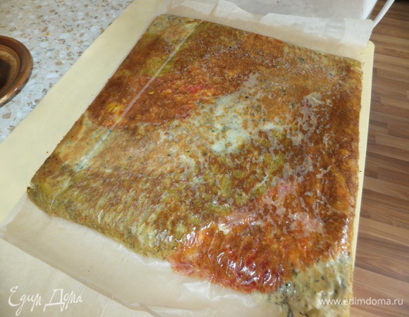 Достаем из духовки готовую пиццу-рулет. Переворачиваем ее на второй пергаментный лист и даем остыть. Снимаем пергамент, выбираем красивую сторону, а некрасивой стороной кладем наверх)