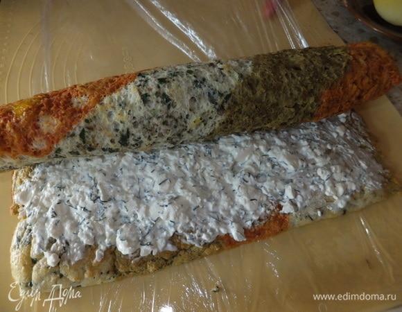 И с помощью пищевой пленки сворачиваем в рулет. Ставим в холодильник на полтора часа.