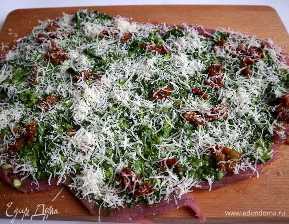 Посыпать сверху пармезаном. Часть пармезана оставить, чтобы посыпать рулет.