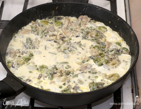 Добавить мелконарезанный чеснок. Добавить нарезанный плавленнй сыр. Перемешать до полного растворения сыра. Залить сливки. Тушить 5 минут.