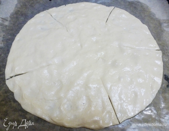 Бумагу для выпечки смазать растительным маслом. Растянуть тесто, формируя круг. Сделать пять надрезов, но не до конца (середина должна быть целой).