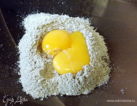 Сделать ямку в середине муки и положить желтки. Замешивать тесто, начиная с середины и постепенно захватывая края.