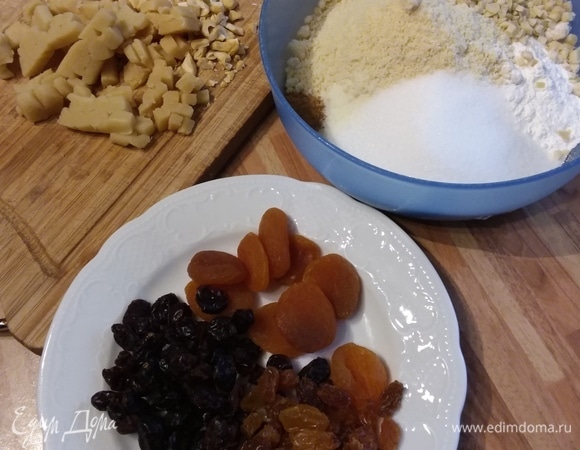 В миске смешать муку, разрыхлитель, соль, сахар, молотый в мелкую крошку миндаль. Фисташки и миндаль крупно порубить и добавить к муке. Также порубить марципан, курагу, клюкву и изюм (если он крупный).