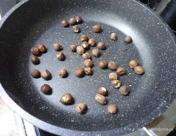 Орехи подсушить на сухой сковороде, очистить от кожицы и измельчить.