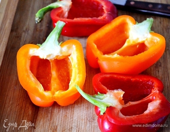 Разрезаем перцы пополам (вместе с хвостиком) и убираем семена. Каждый перец смазываем растительным маслом и солим.