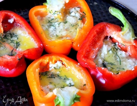 В перцы кладем измельченный сыр с зеленью. Если яйца мелкие, в каждую половинку перца кладем по 1 яйцу. Если крупные, разбиваем яйца в миску, размешиваем и поровну распределяем по перцам.