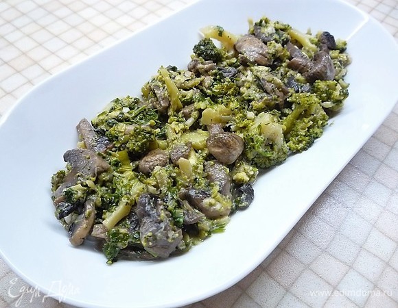 На дно сервировочного блюда выкладываем ароматную брокколи с грибами.