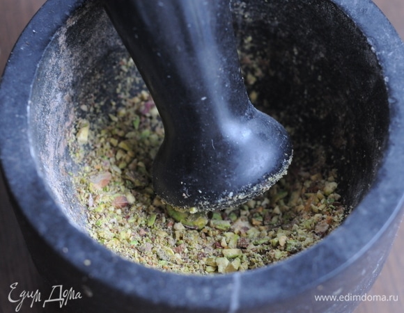 Измельчить фисташки или размять орешки в ступке.