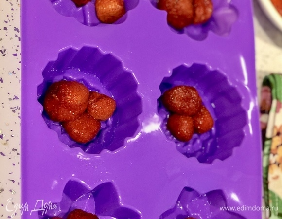Раскладываем клубнику (по 2–3 штуки) в каждую формочку.