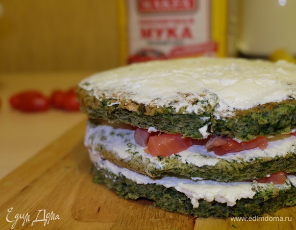 А теперь самое интересное — приступаем к сборке торта. Поверхность коржа смазываем сырно-сливочным кремом, далее выкладываем слой рыбы.