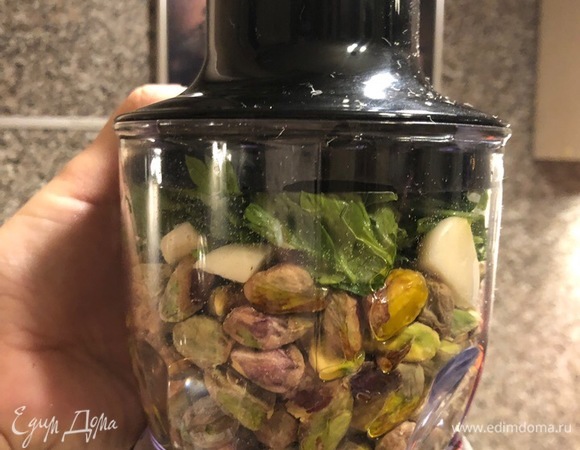 Свежие или размороженные спинки трески выкладываем на противень. Посыпаем приправами (я предпочитаю орегано, сумах, паприку) и добавляем лавровый лист для аромата. Готовим соус для запекания: 300 г очищенных фисташек, три зубчика чеснока, петрушку, укроп, оливковое масло (пару столовых ложек) измельчаем в блендере.