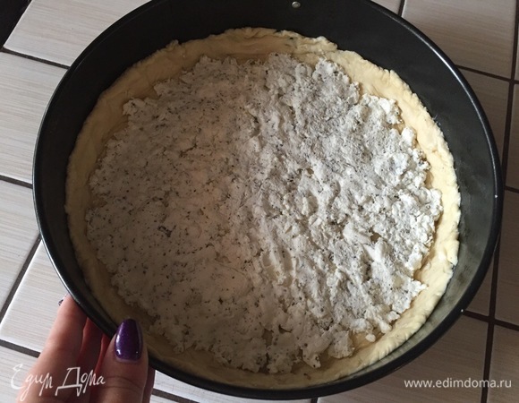 Слоеное тесто равномерно распределяем по форме для выпекания. Сверху распределяем творожный сыр.