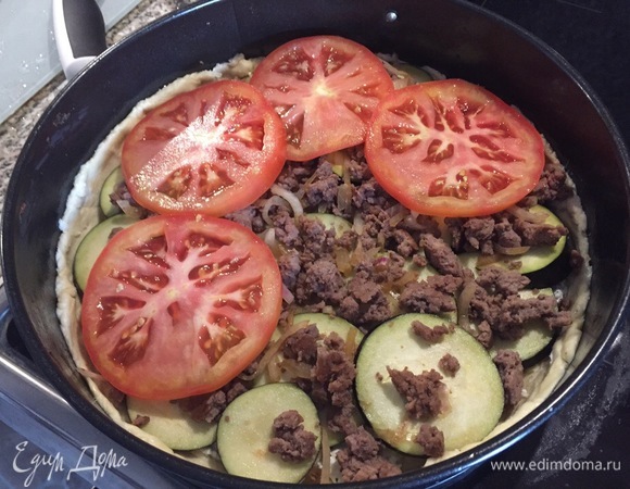 На фарш выкладываем нарезанные кружочками помидоры.