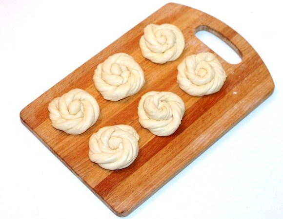 Полоски теста перекрутите несколько раз, а затем скрутите спиралькой. Формовка называется «Твист».