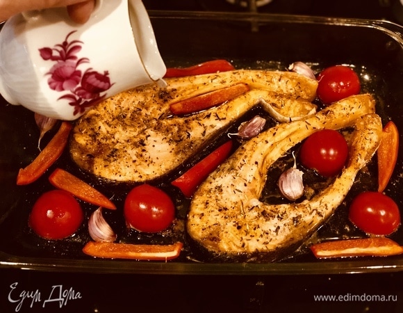 За 8–10 минут до окончания запекания выкладываем по краям к рыбе помидоры черри, сладкий перец и чеснок в кожуре (так он лучше сохраняет свои витамины). Сбрызгиваем все овощи оливковым маслом.