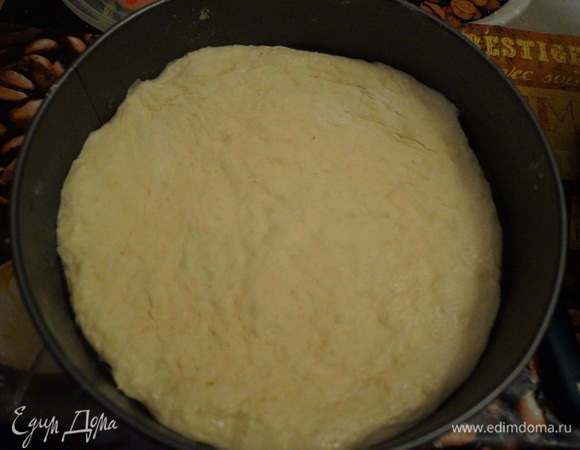 Половину теста выкладываем на дно смазанной маслом формы и распределяем по дну.