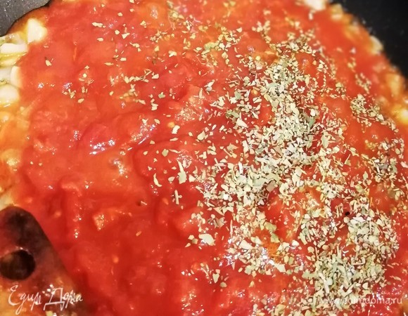 Тем временем займемся начинкой. Вначале приготовим вкусную томатную пасту. В оливковом масле пассеруем 1 луковицу, добавляем свежие или протертые консервированные томаты, прованские травы (орегано, базилик, тимьян), немного соли и провариваем массу 3 минуты.