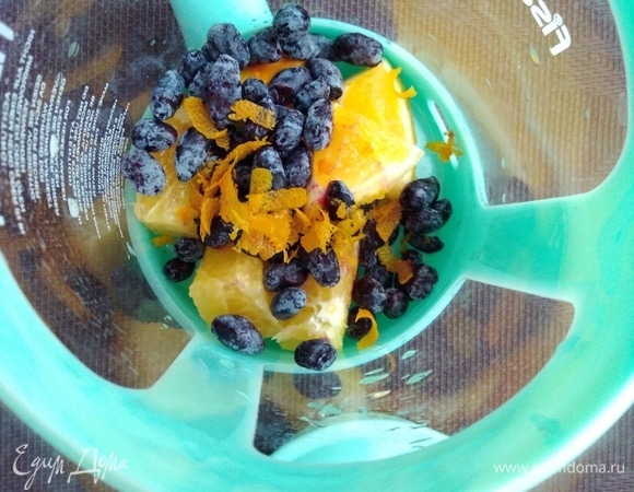 Заварочный чайник или френч-пресс обдать кипятком. С апельсина снять цедру и несколько долек нарезать кубиками. Поместить все в чайник. Всыпать ягоды. Я брала замороженную жимолость. Можно по вкусу взять любую другую.