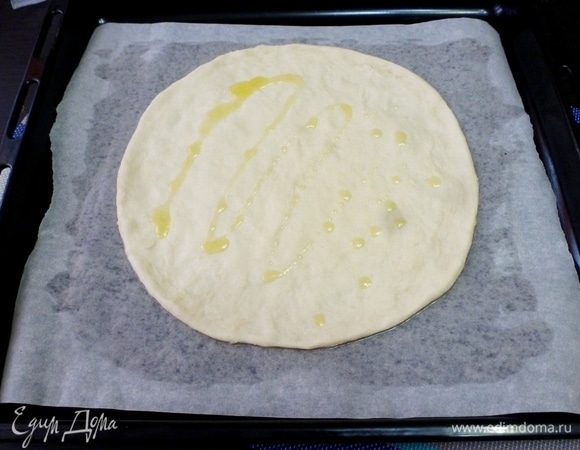 Из теста сформировать круглую лепешку и сбрызнуть ее оливковым маслом.