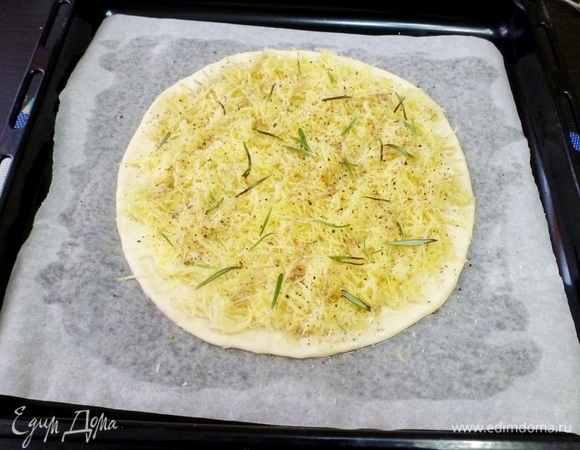 Равномерно распределить по лепешке натертый картофель. Посыпать листиками розмарина, поперчить и посолить. Снова полить оливковым маслом.