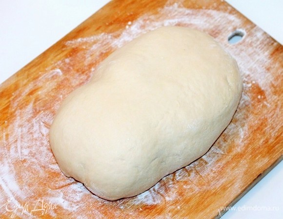 Посыпаем разделочную доску мукой и кладем заготовку с начинкой, формируем брюшко поросенка.
