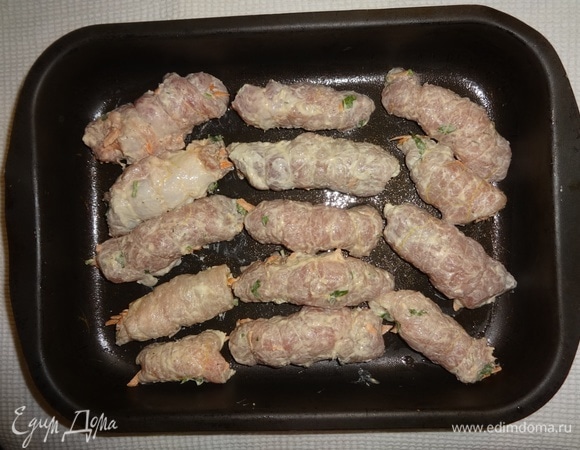 Выложить рулетики в смазанную растительным маслом форму. Накрыть форму фольгой. Поставить в духовку, разогретую до 180°C, на 40 минут. Достать форму из духовки, снять фольгу. Вытащить рулетики, немного остудить их и снять с них нитки.