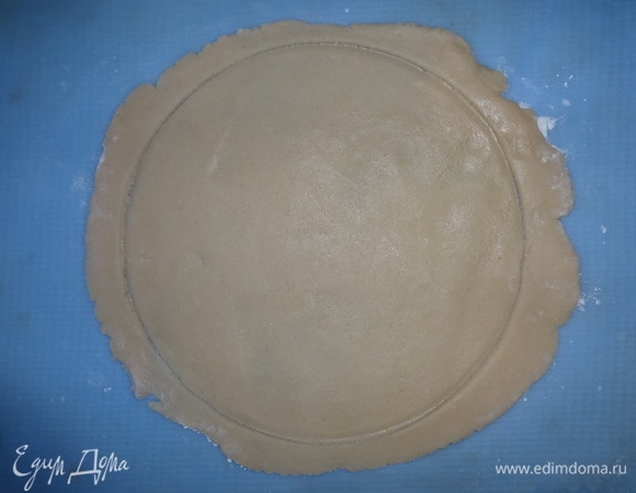 На посыпанном мукой силиконовом коврике раскатать лепешки по размеру формы для выпекания. Чтобы вырезать ровный круг, можно использовать тарелку, равную диаметру формы. Выкладывать лепешки в форму удобно с помощью того же силиконового коврика. Обрезки можно скатать в шар и раскатать еще один пласт.