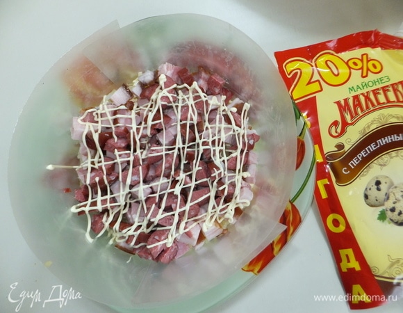 Отвариваем картофель, морковь, свеклу и яйца до готовности. На блюдо ставим воротник из пленки. Нарезаем грудинку и колбасу мелким кубиком. Делаем майонезную сеточку корнетиком (майонез с перепелиным яйцом ТМ «МахеевЪ»).