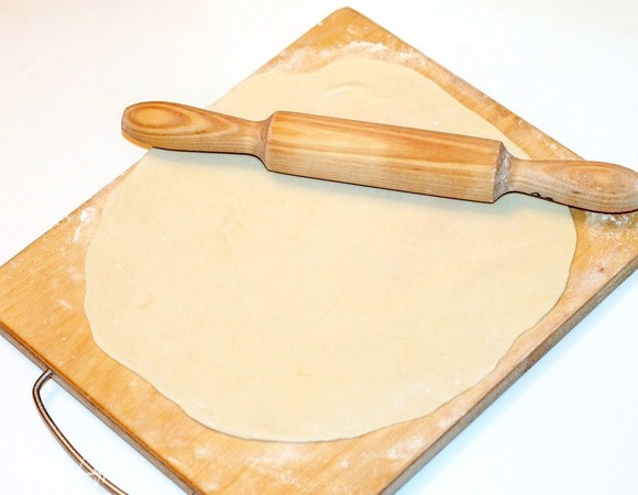 Тесто разделите на 4 части. Три части теста кладем в чашу, накрываем полотенцем. Четвертую часть делим на 3 кусочка. С помощью муки очень тонко раскатайте каждый кусочек теста в круг диаметром 24 см. Он должен просвечиваться и быть толщиной не более 1 мм.