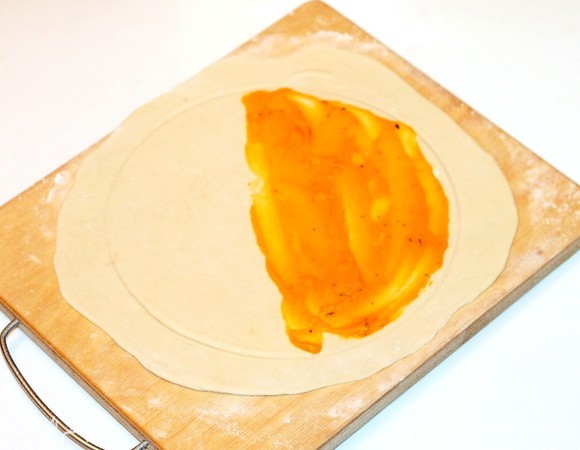 Смажьте половину круга диаметром 20 см тыквенной начинкой (1,5 ч. л.).