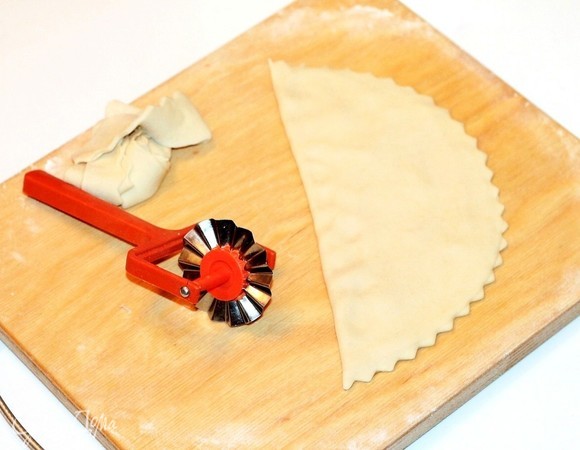 Аккуратно обрежьте специальным колесиком край круга. Остатки теста положите в чашу под полотенце.